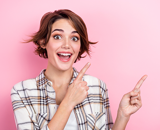 Portrait of crazy young woman brown hair direct fingers empty space useful tips proposition ad promoter isolated on pink color background.
